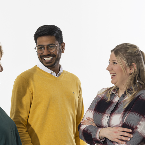 Eine Gruppe Auszubildender steht zusammen und tauscht sich aus.